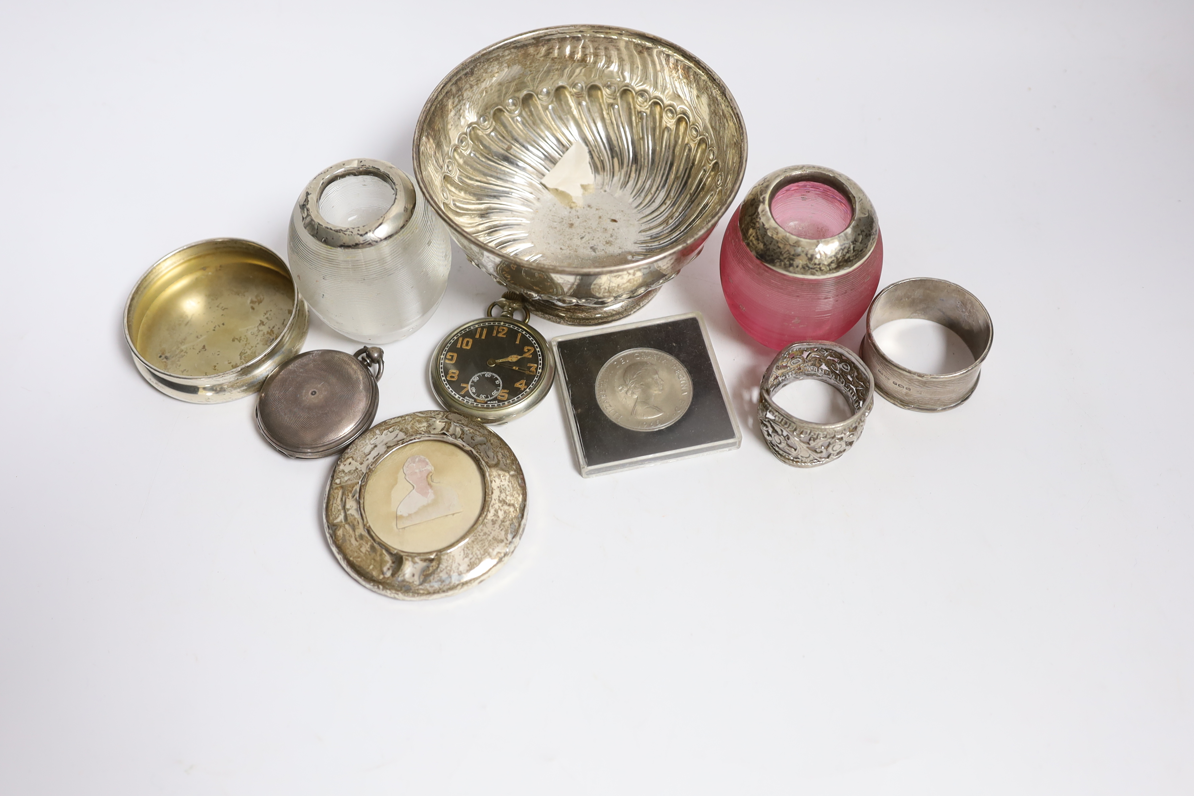 A collection of small silver, to include two mounted glass match strikes, one with cranberry glass, 71mm, a demi fluted bowl, photograph frame, napkin ring, lid and pocket watch, together with one other pocket watch, a c